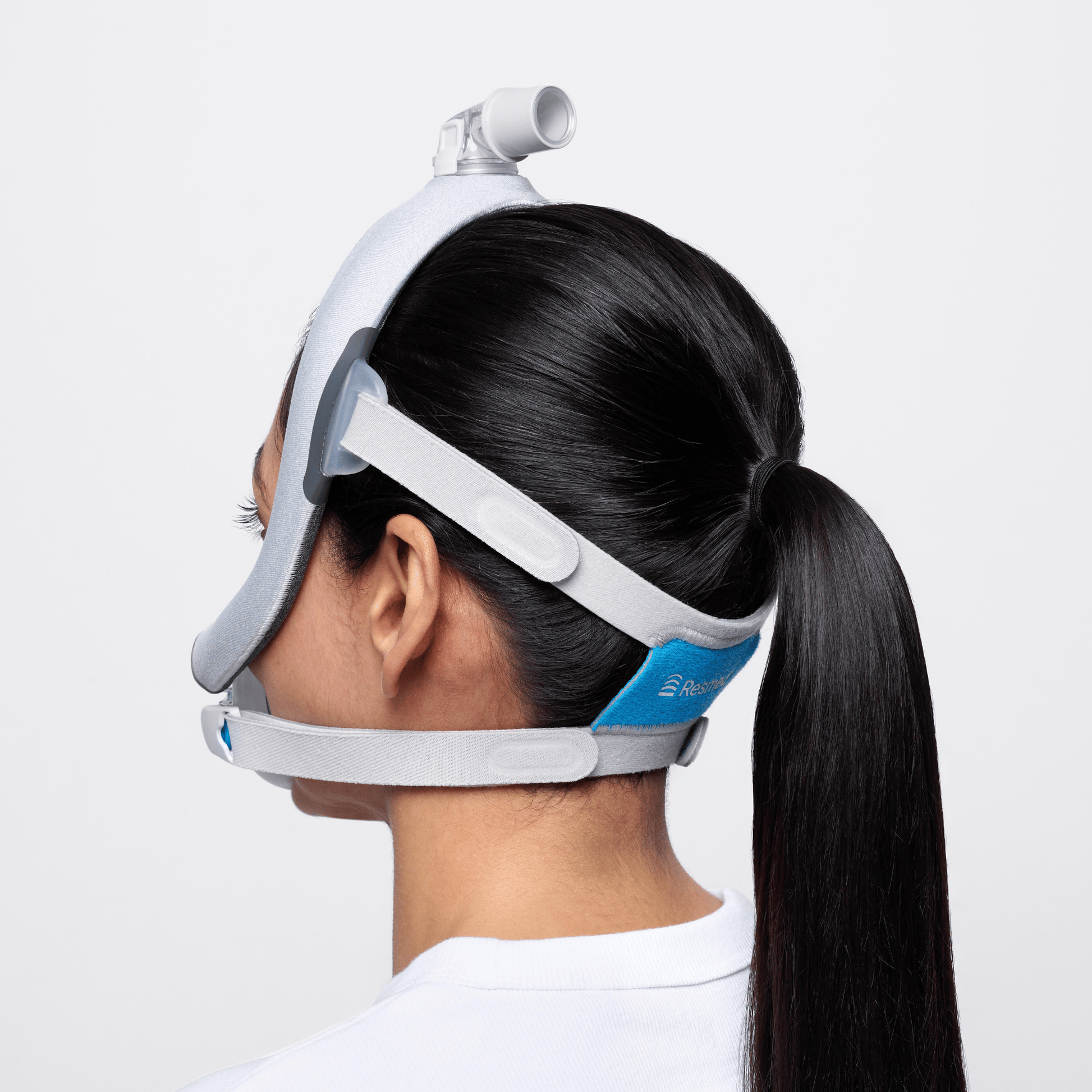 Rear view of woman wearing AirTouch F30i Comfort showing how the headgear cradles the head and leaves room for a pony tail or long hair