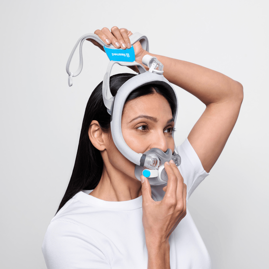 Woman slipping the AirTouch F30i Comfort mask onto her head
