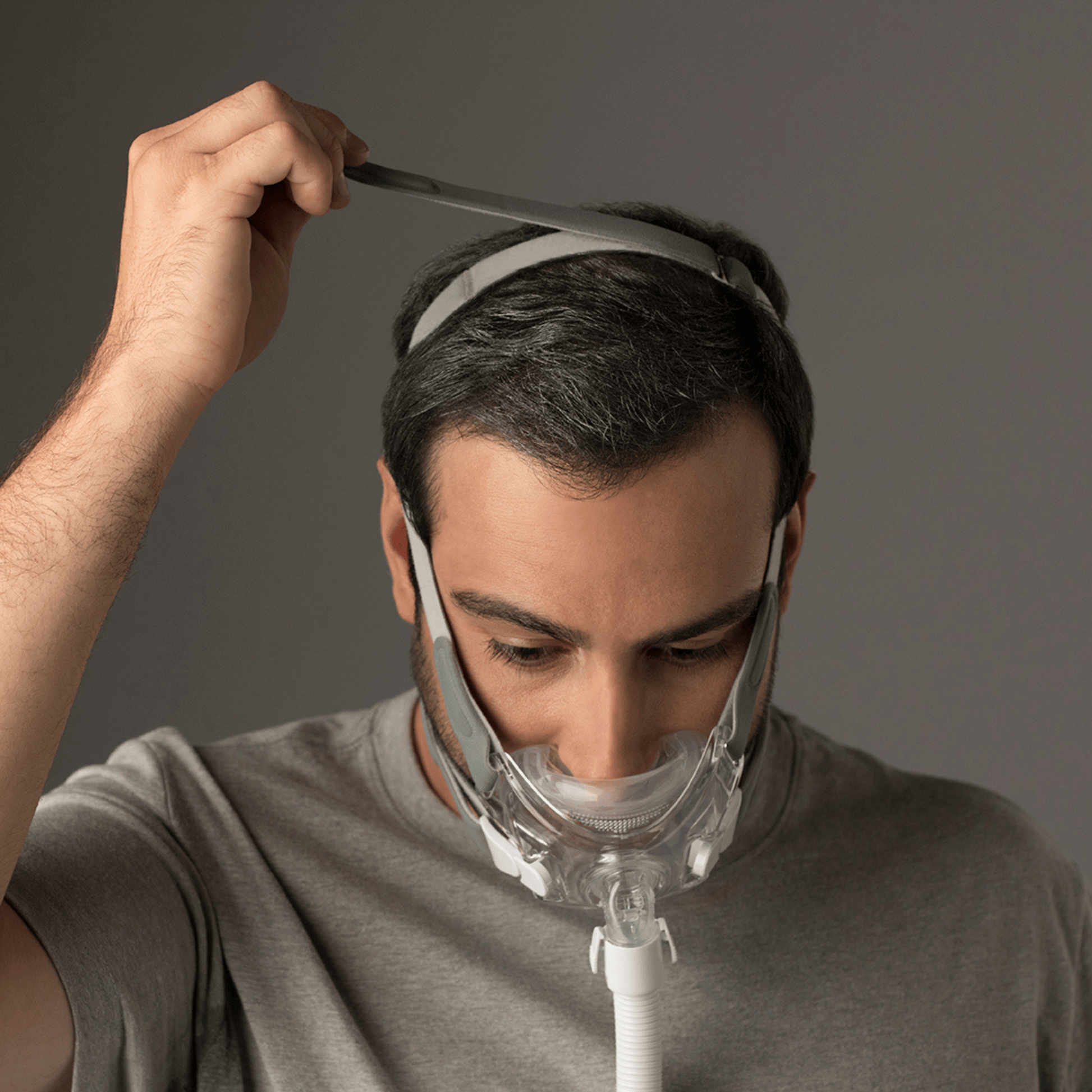 man wearing amara view mask adjusts the crown strap at the top of the head