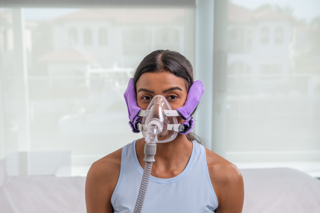 Front view of a woman wearing Snugell CPAPstrapCover in purple, enhancing comfort and reducing strap irritation.