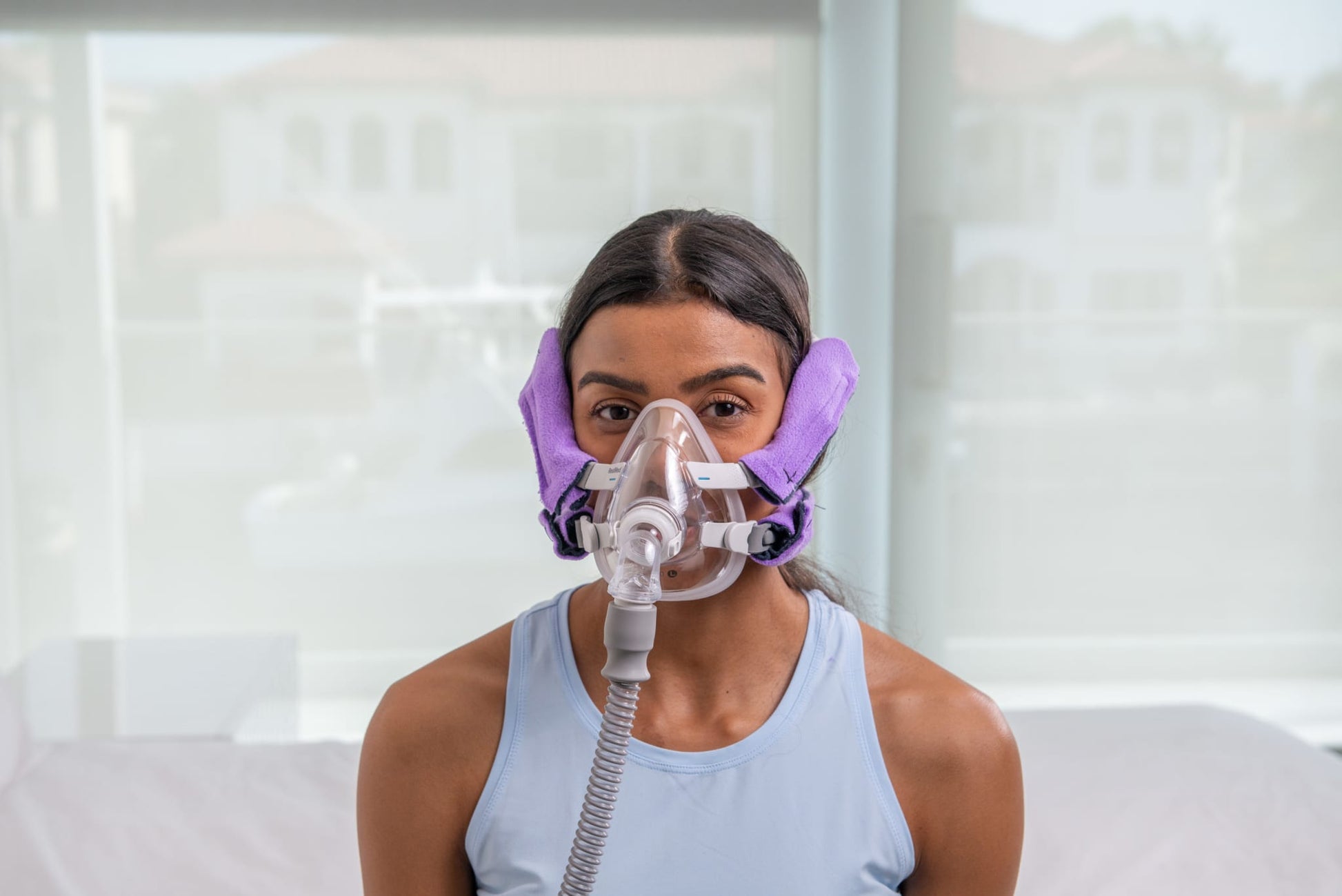 Front view of a woman wearing Snugell CPAPstrapCover in purple, enhancing comfort and reducing strap irritation.